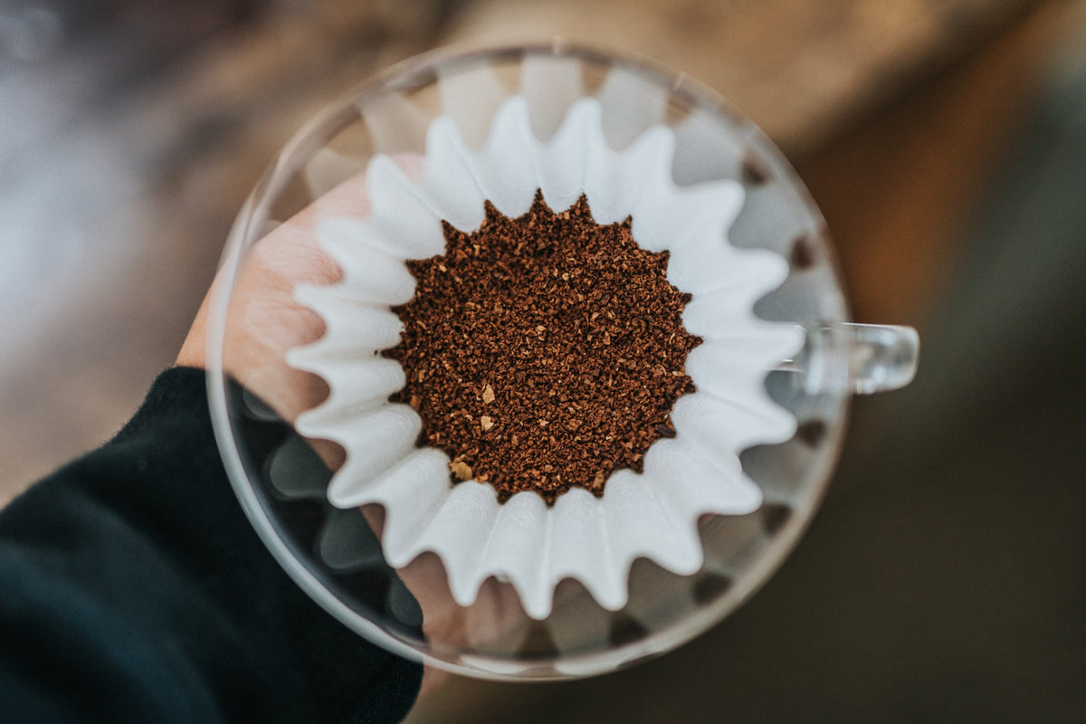 Kalita Papierfilter mit gemahlenem Kaffee in einem Glasdripper