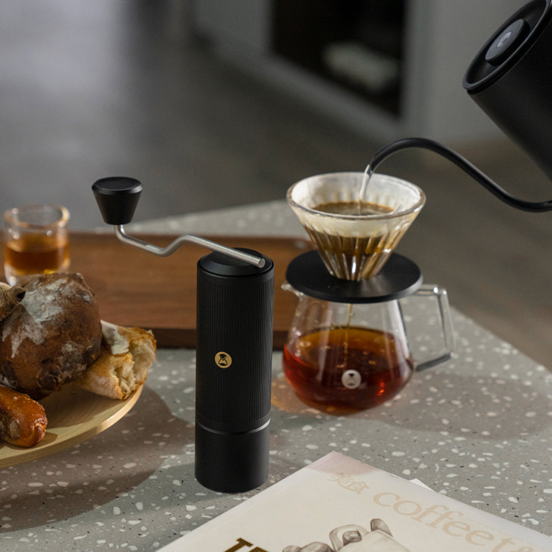 Timemore X-Lite Handmühle schwarz mit Timemore Kanne, Dripper und Wasserkessel während des Brühvorgangs